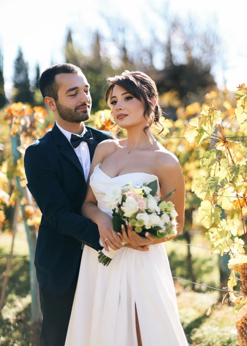 A couple in a white conservatory filled with light and greenery
