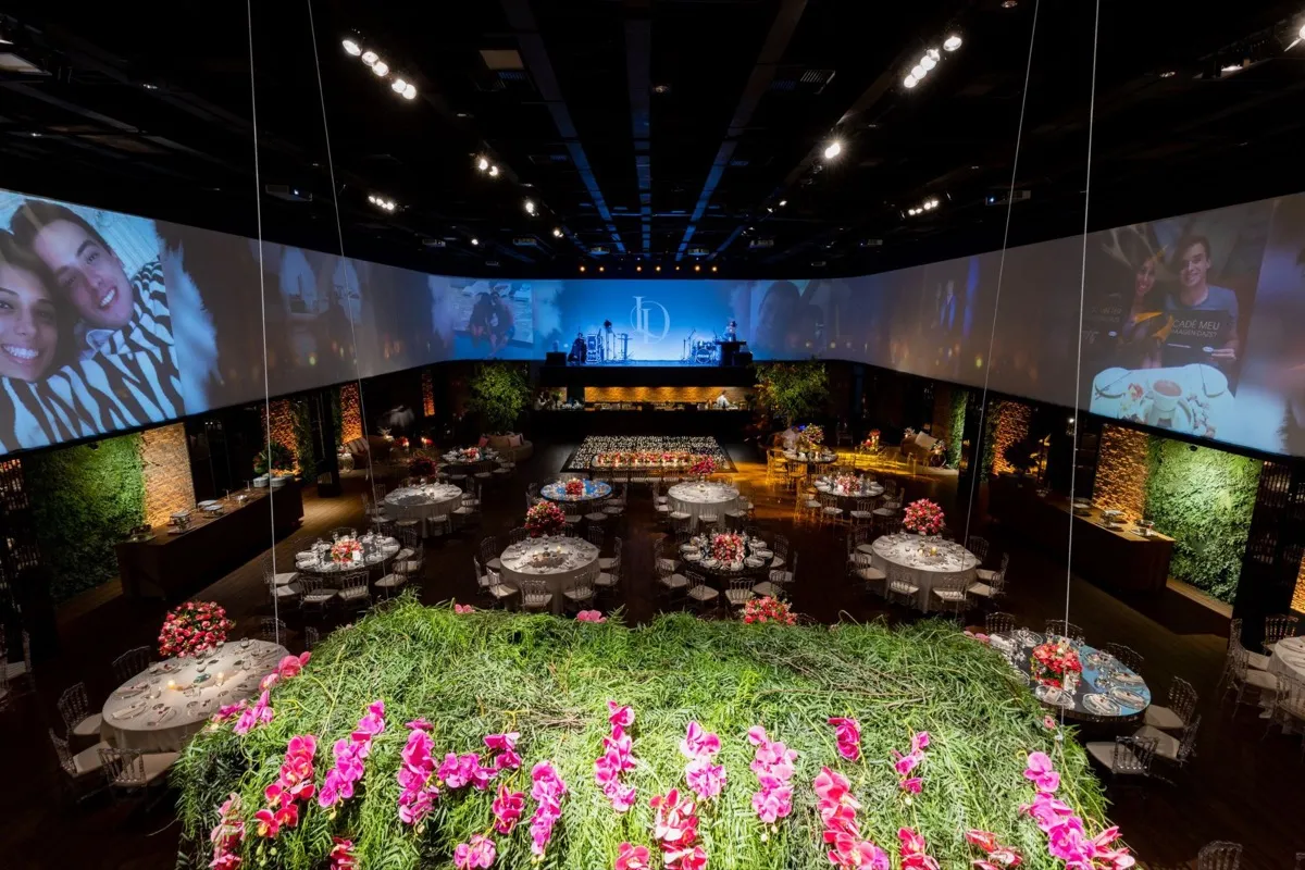 A candlelit long table in a heritage room with a painted floral frieze